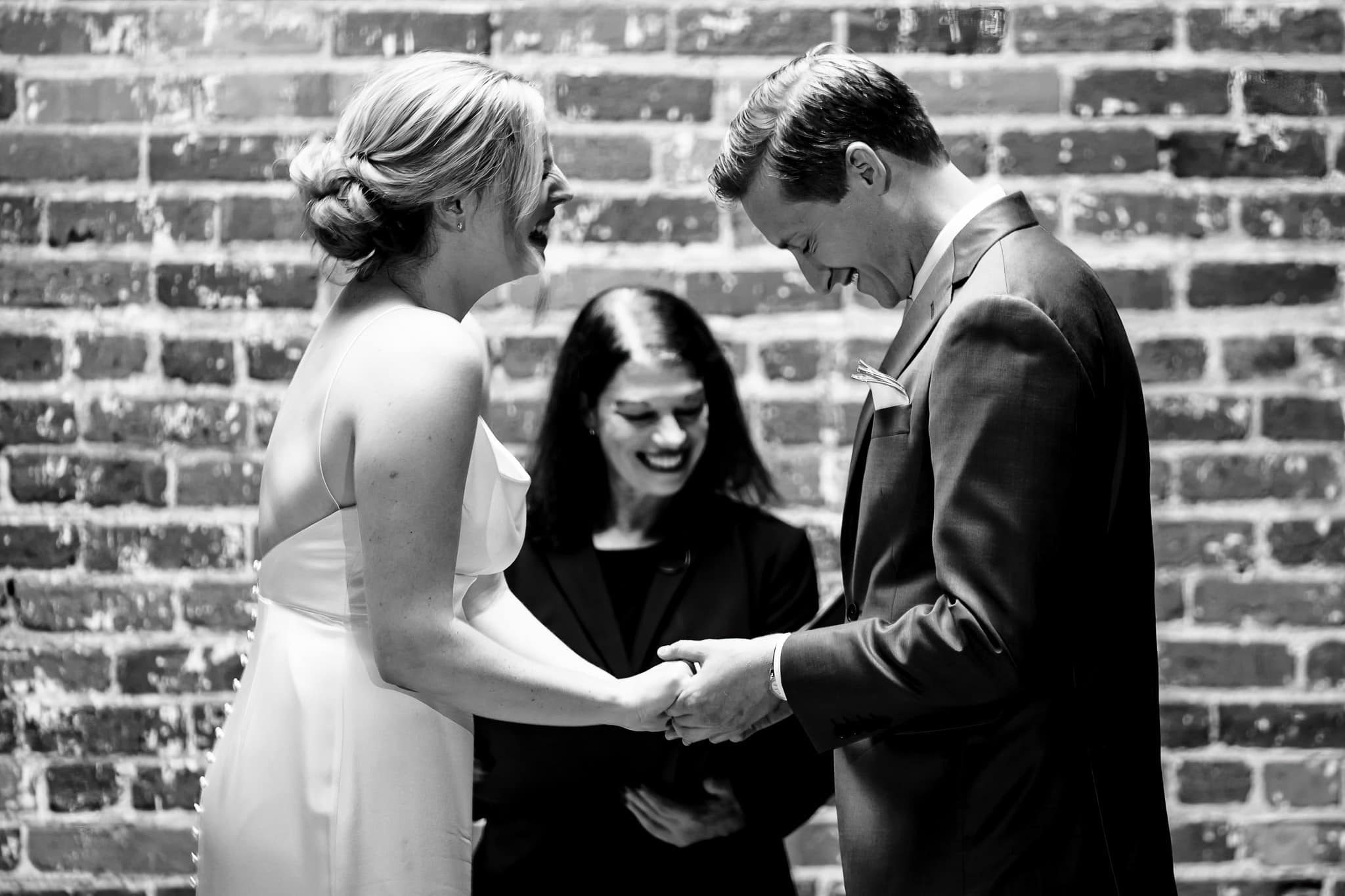 couple laughs during indoor wedding ceremony at The Grove at City Market | photo by Kivus & Camera
