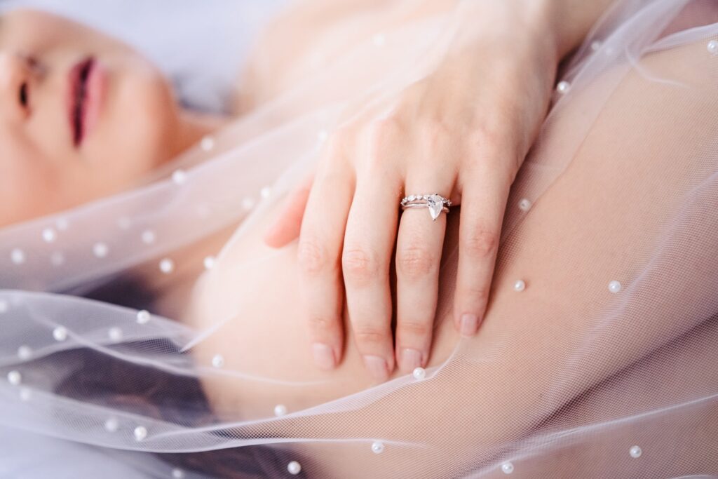photo of a woman's hand with an engagement ring and a wedding veil | Triangle Boudoir by Kivus & Camera