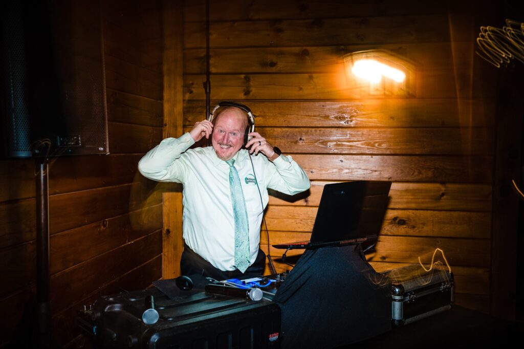 Brian from McSound Productions smiles behind his DJ booth at a wedding | photo by Kivus & Camera