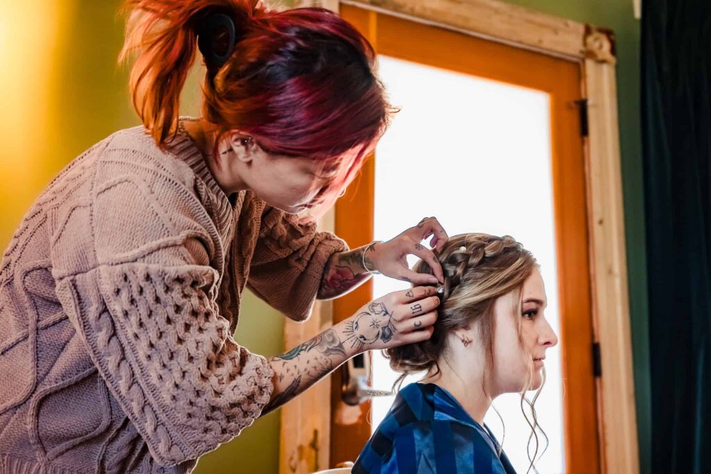 stylist from Reign Beauty works on a bridesmaid's hair | photo by Kivus & Camera