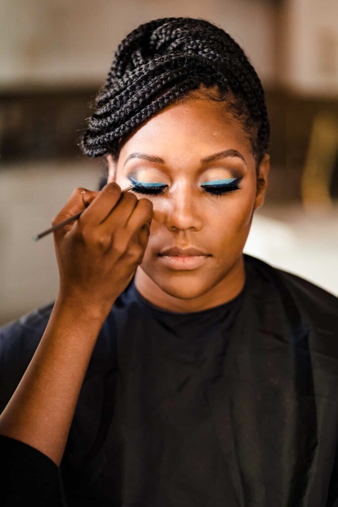 Sharon Davis Makeup Artistry applies teal eye shadow to a black bride in Durham, North Carolina | photo by Kivus & Camera