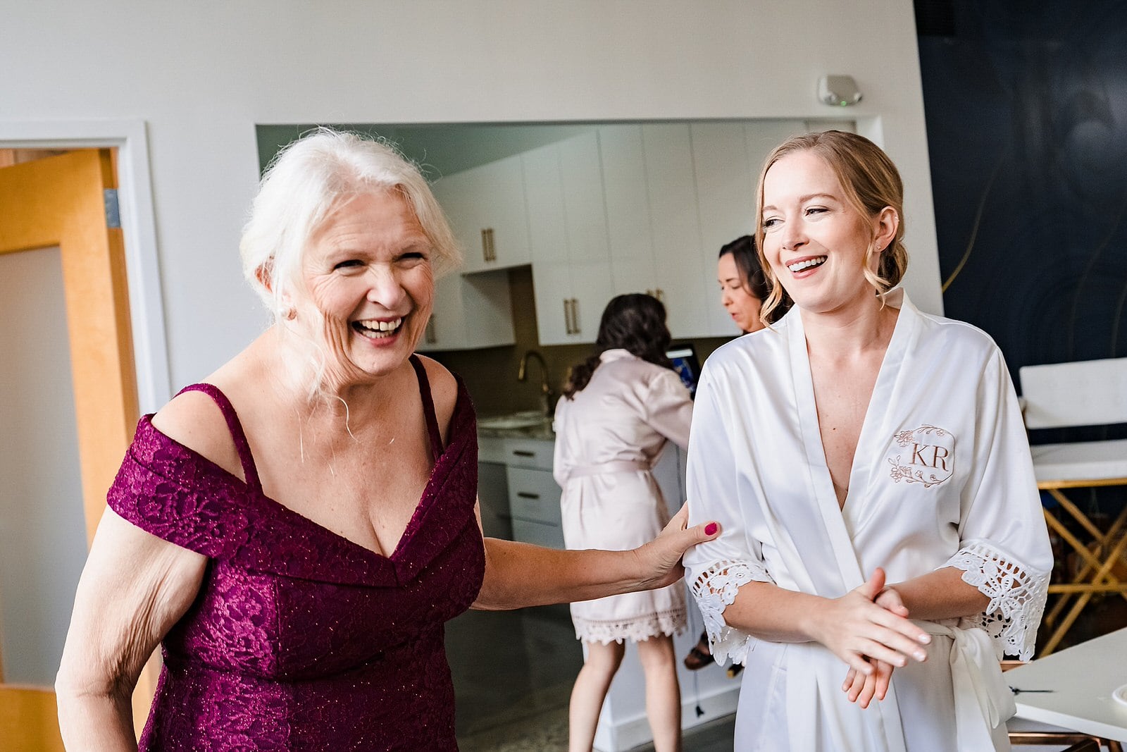 Bride laughs with her mother on her wedding morning