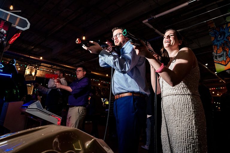 Bride and groom playing arcade games at a Boxcar Bar + Arcade wedding by Durham wedding photographers Kivus & Camera