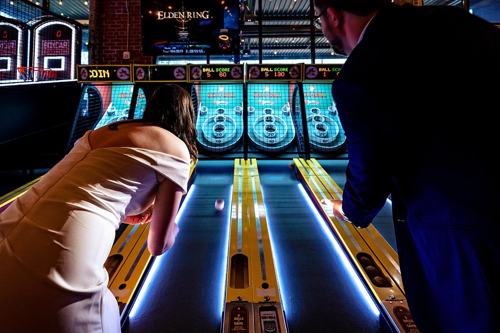Bride and groom playing arcade games at a Boxcar Bar + Arcade wedding by Durham wedding photographers Kivus & Camera