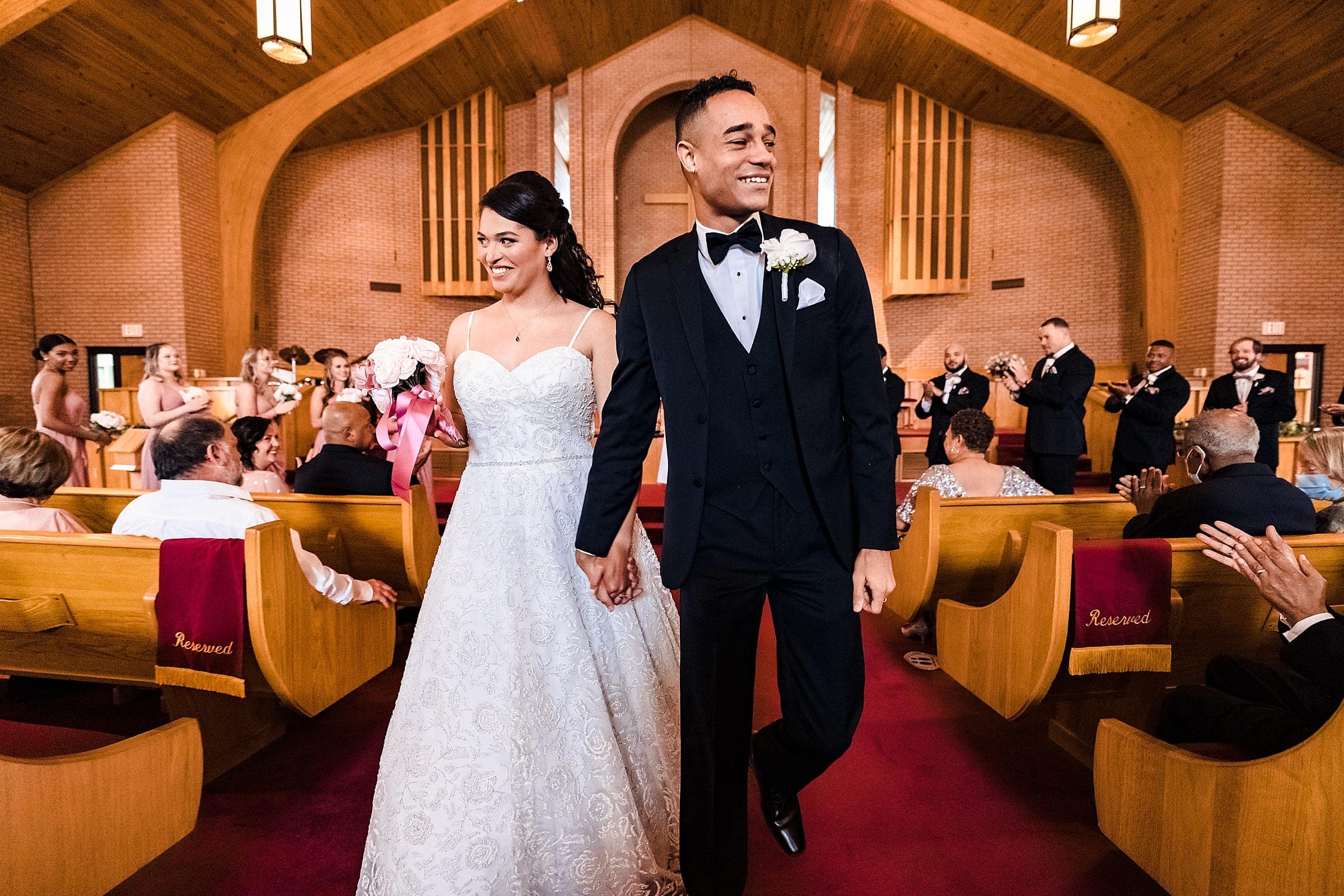 joyful black couple recesses out of the church after their wedding ceremony in Durham, NC | photos by Kivus & Camera