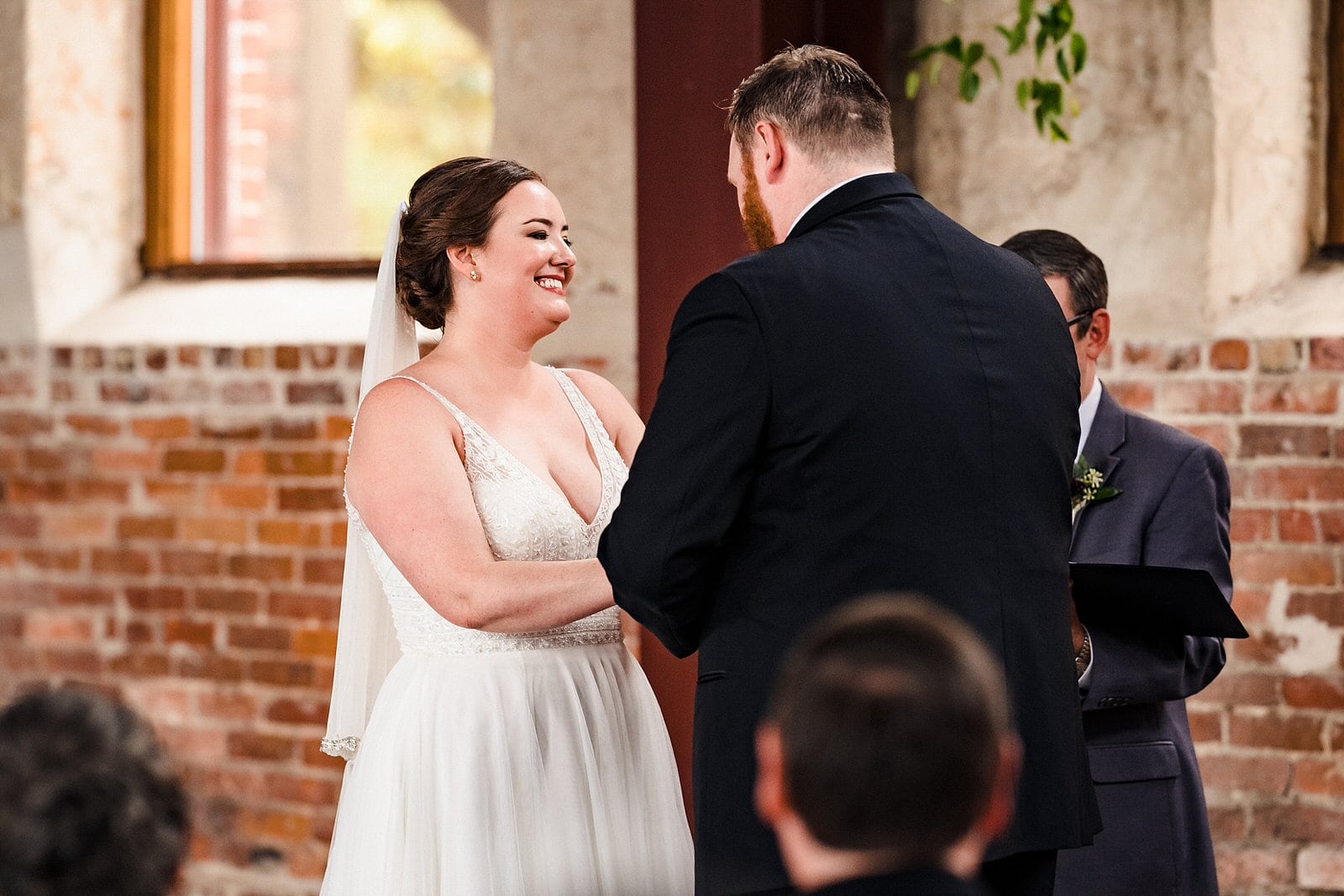 Bride laughs as groom reads his vows
