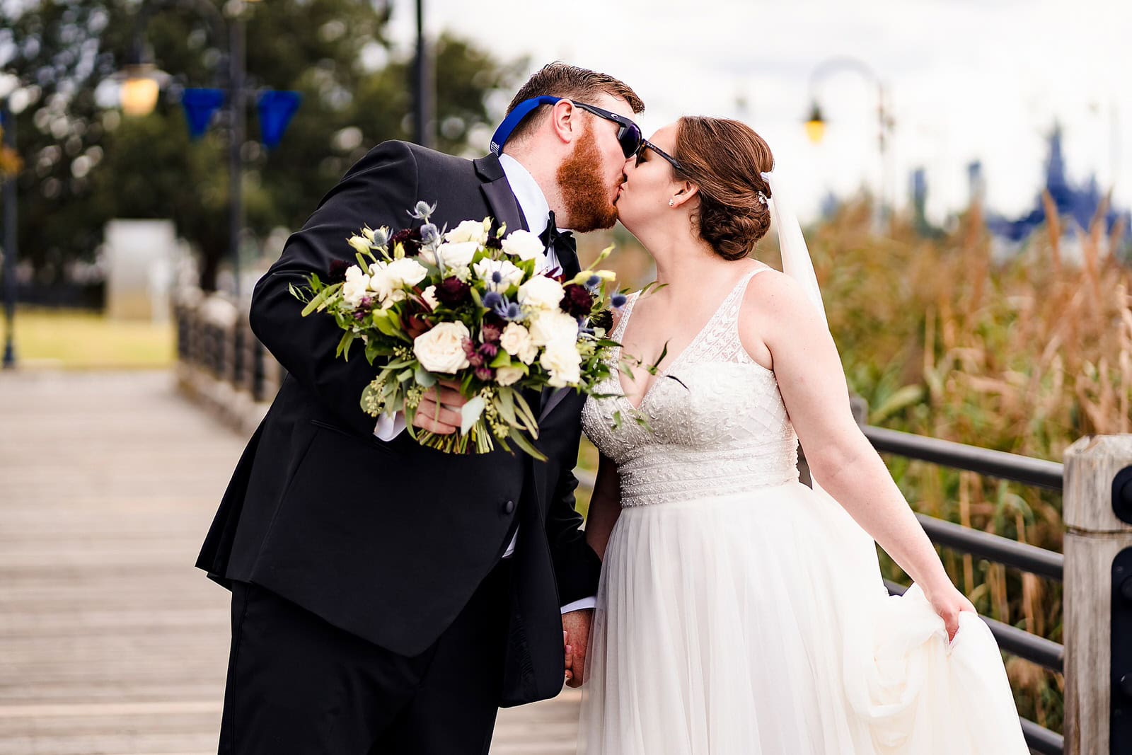 Bride and groom walk down the riverwalk in Wilmington, NC after their Brooklyn Arts Center wedding
