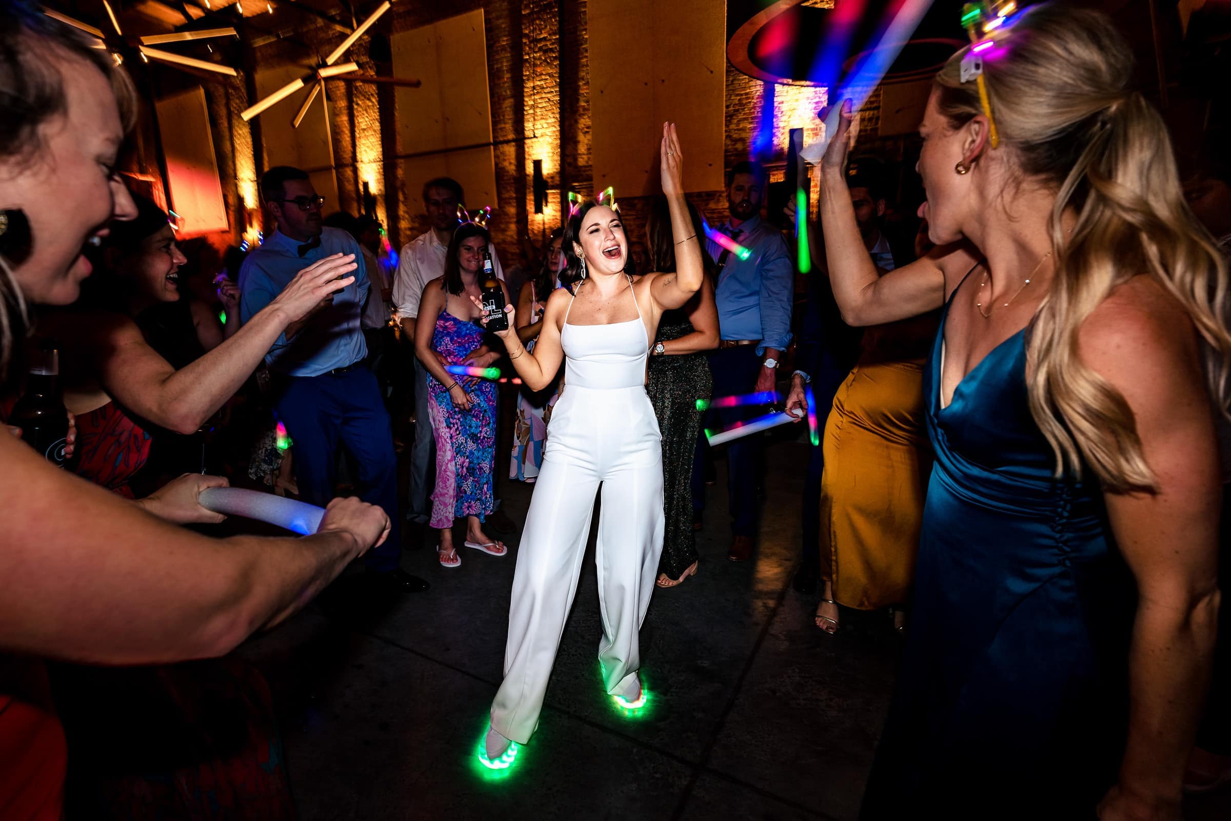 This bride changed into a white jumpsuit and light up sneakers for part of her wedding reception | photos by Kivus & Camera