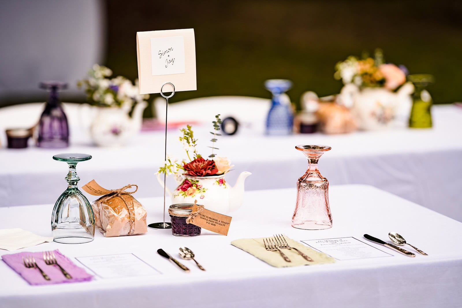 Wedding reception table set with vintage glassware and colorful signage