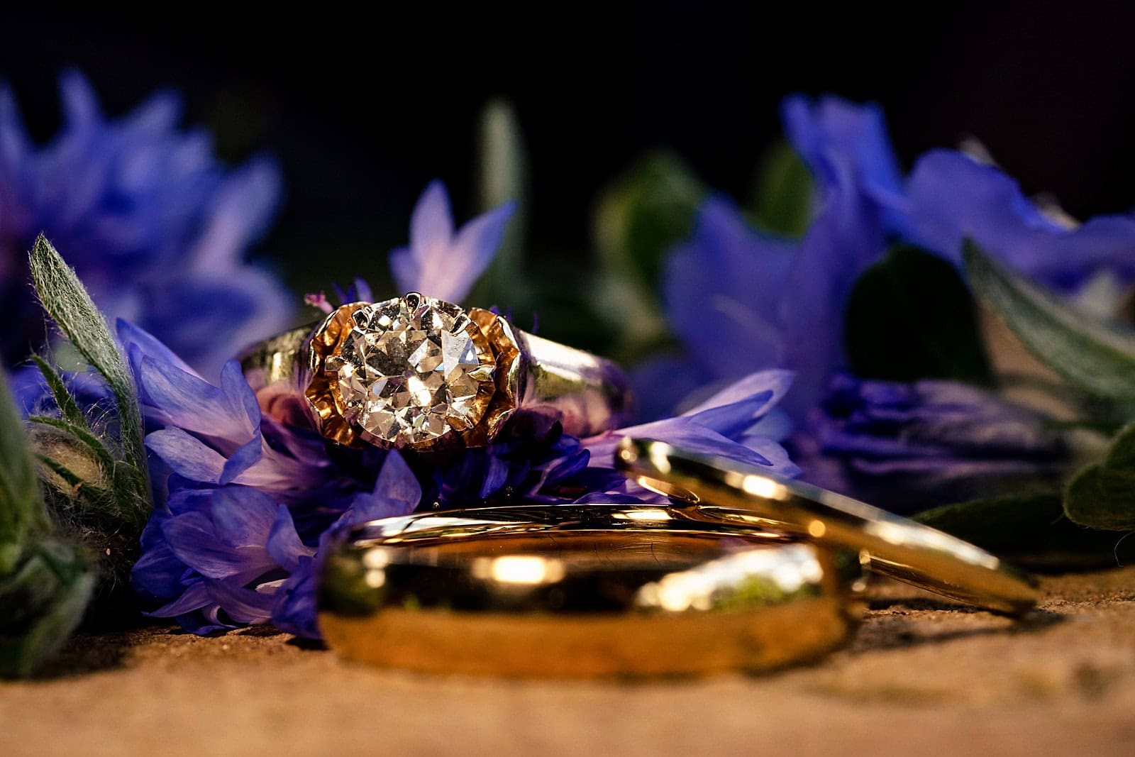 gold and diamond wedding rings with purple flowers