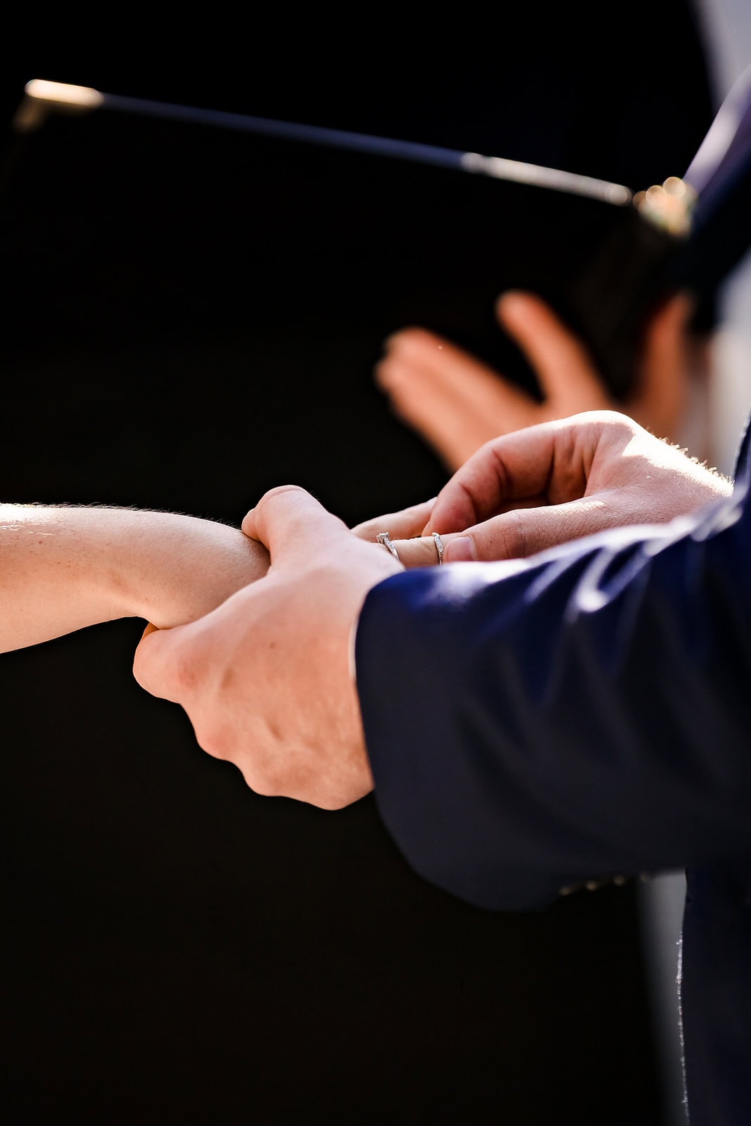 groom places wedding ring on bride's finger