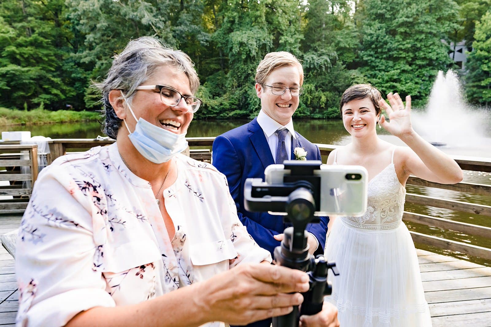 couple waves at people attending their wedding via zoom