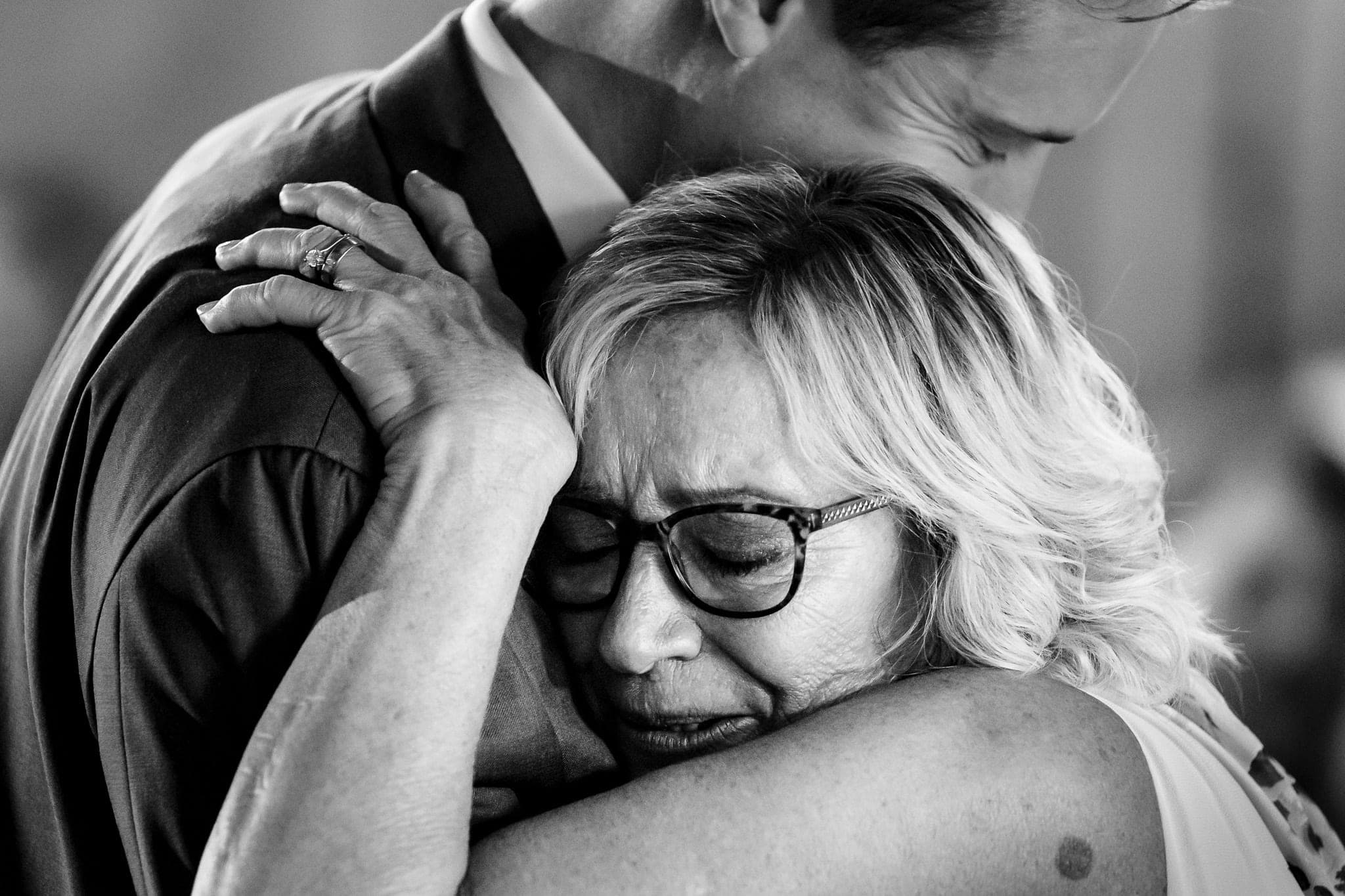 mother of the groom holds back tears as she embraces him during the mother son dance | photo by Kivus & Camera