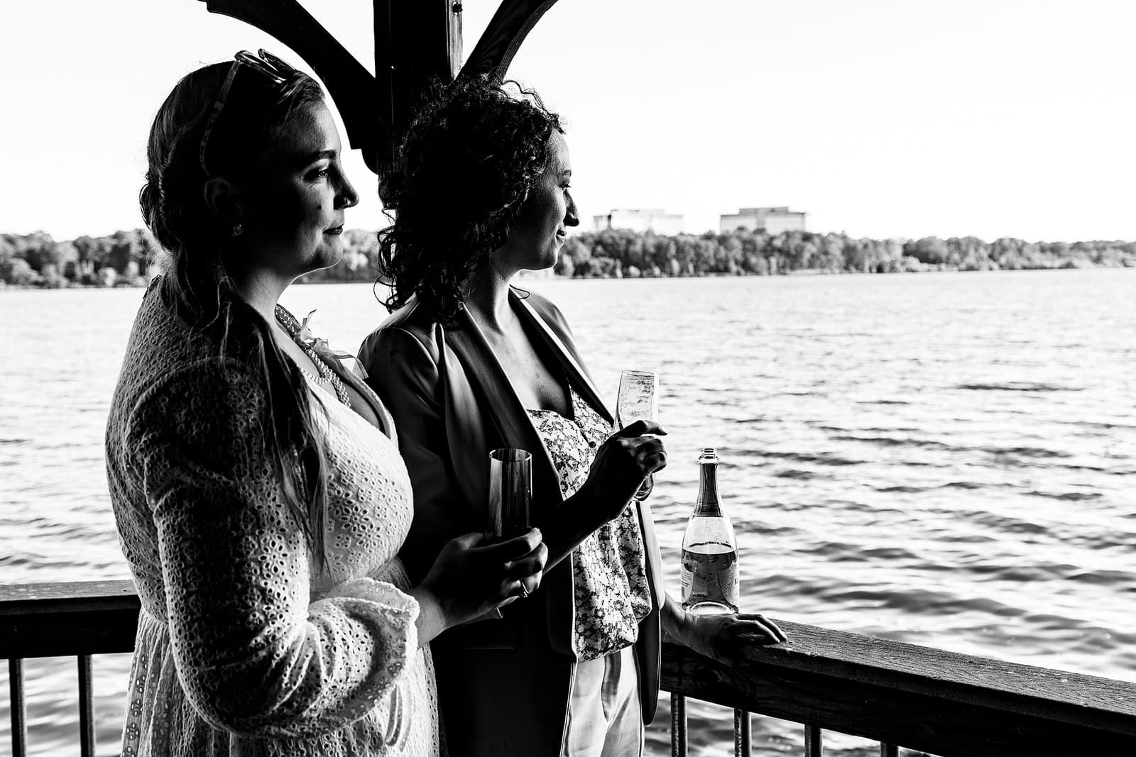 Two women look out at the water right after they have been married in an intimate wedding ceremony