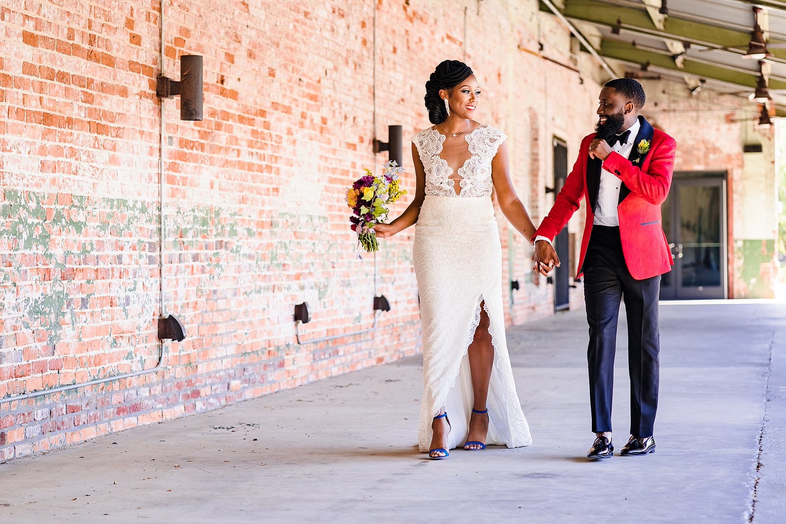 Bride and groom laugh and hold hands as they walk through Belt Line Station