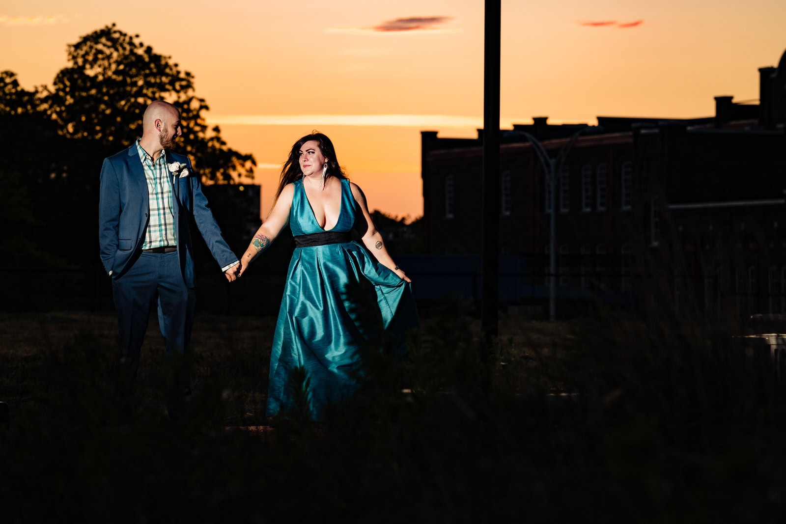 Couple dances in front of an orange sunset during a Durham anniversary portrait session