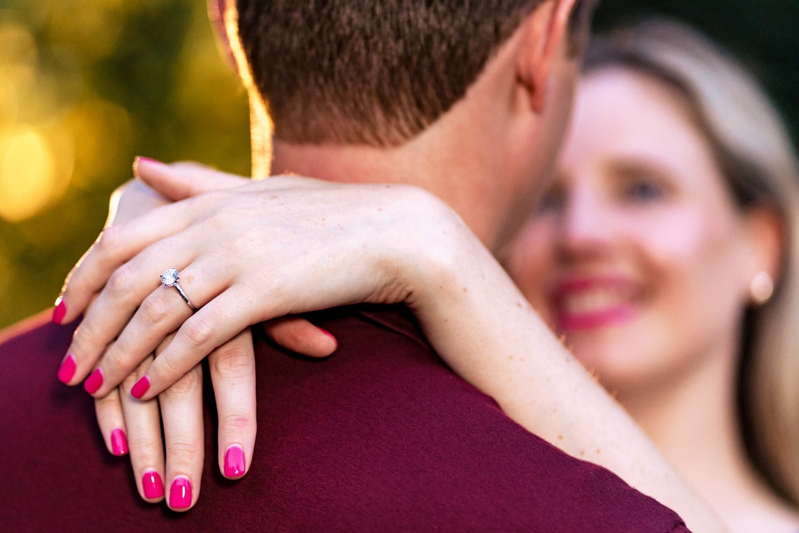 Portrait of a couple, with the focus on the woman's engagement ring creative engagement photography at Killjoy Cocktail bar in Raleigh, NC | photos by Kivus & Camera