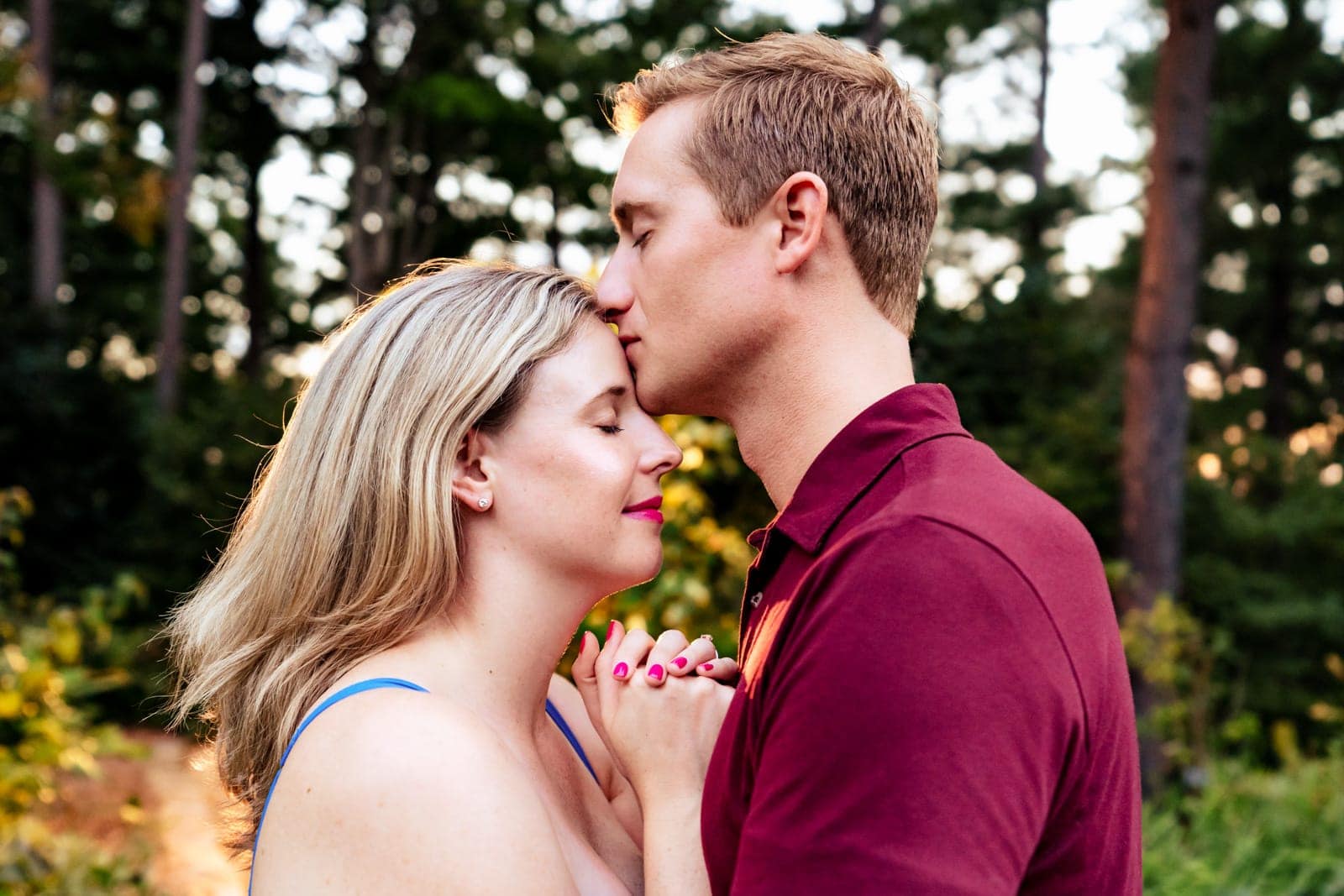 A man kisses his partner's forehead creative engagement photography at Killjoy Cocktail bar in Raleigh, NC | photos by Kivus & Camera