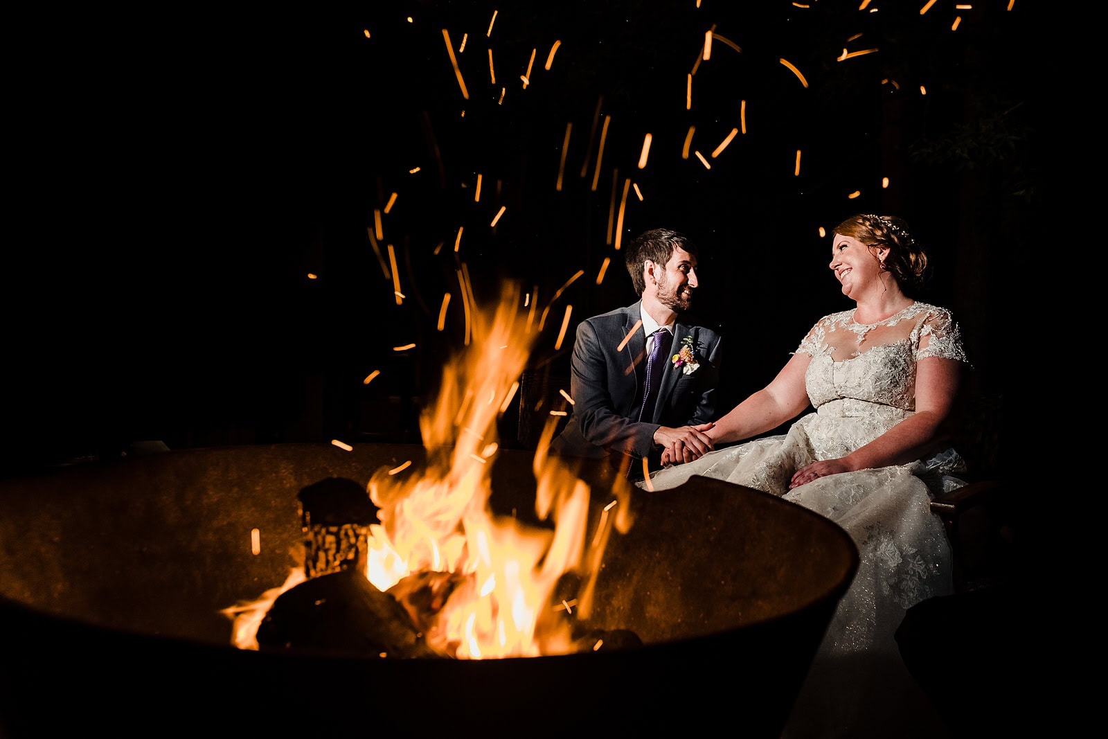 Bride and groom wedding portrait next to a bonfire