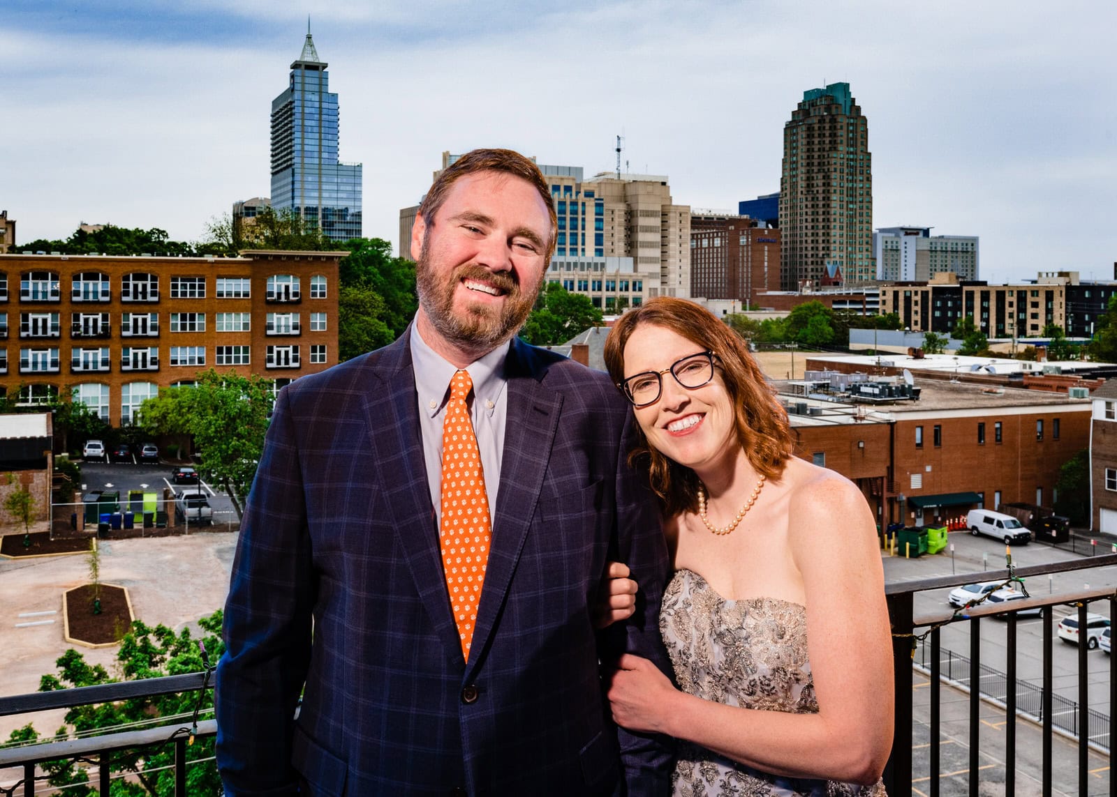 Bride and groom pose with the downtown raleigh skyline as part of the big fake quarantine wedding project