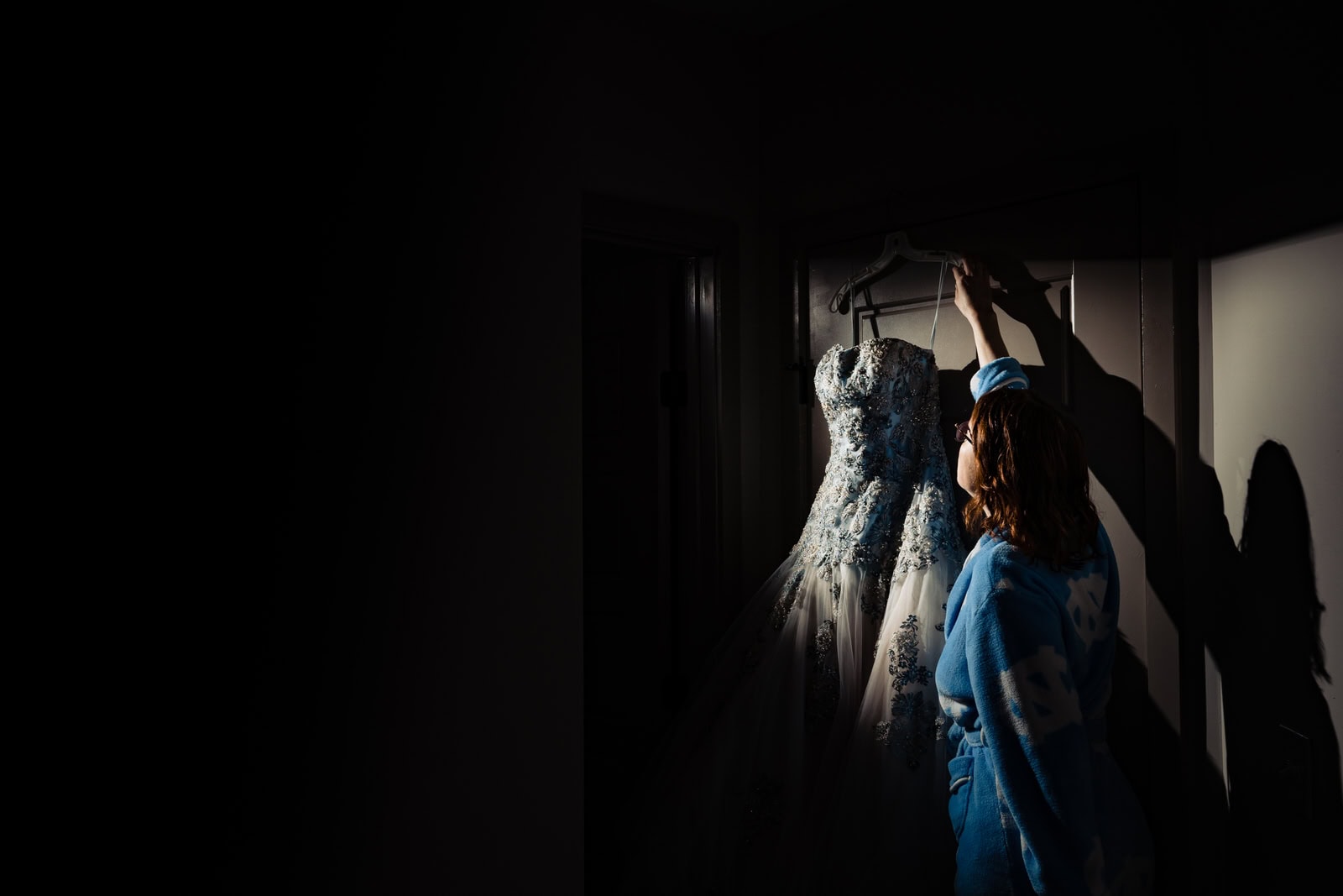 bride reaches for her wedding dress before big fake quarantine wedding