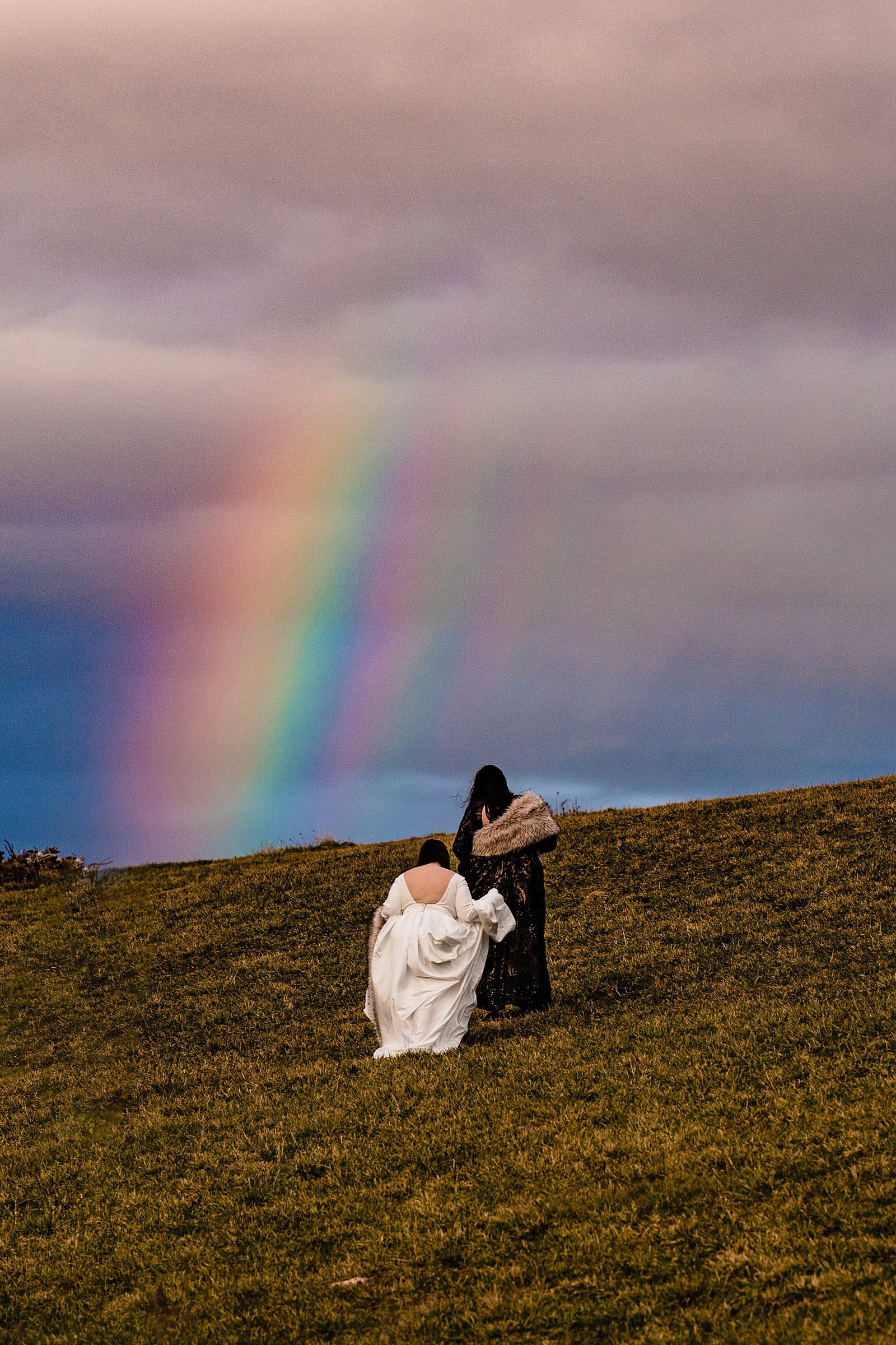 Same-sex wedding portraits with a rainbow