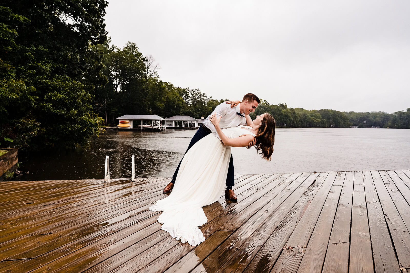 Groom dips bride in front of a dramatic stormy sky