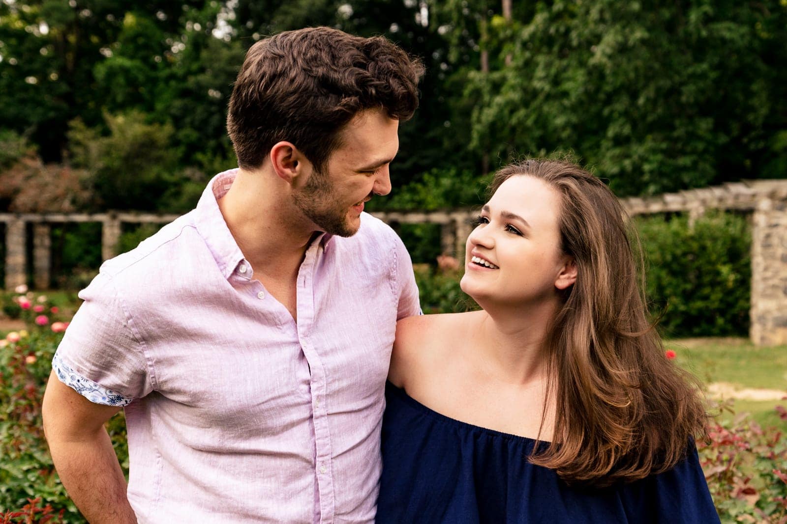 engaged couple smiles at one another