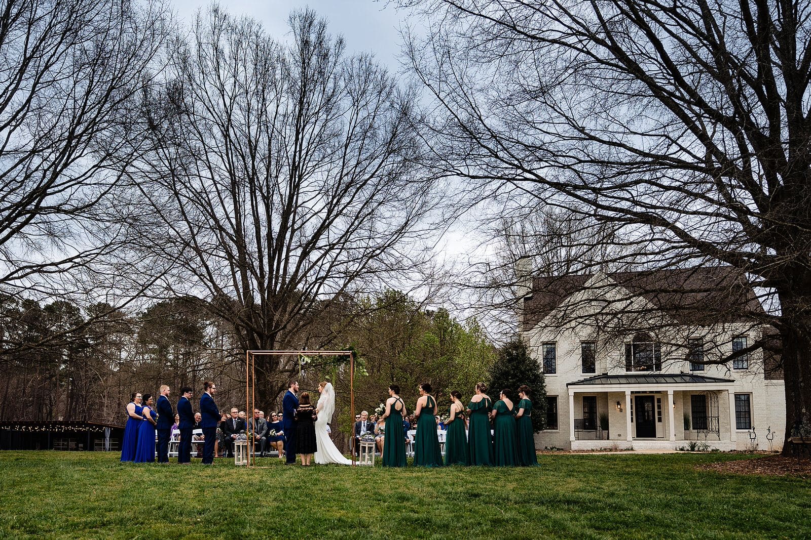 Outdoor wedding ceremony on the lawn of Aerie House at The Meadows Raleigh by Raleigh wedding photographers