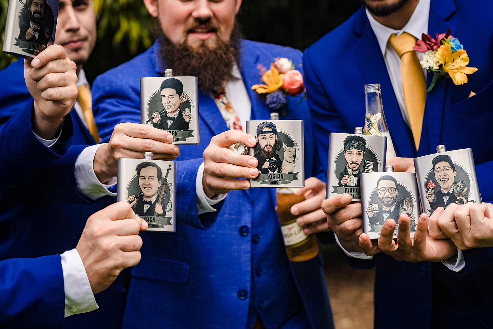 Groom and groomsmen toast with their custom flasks