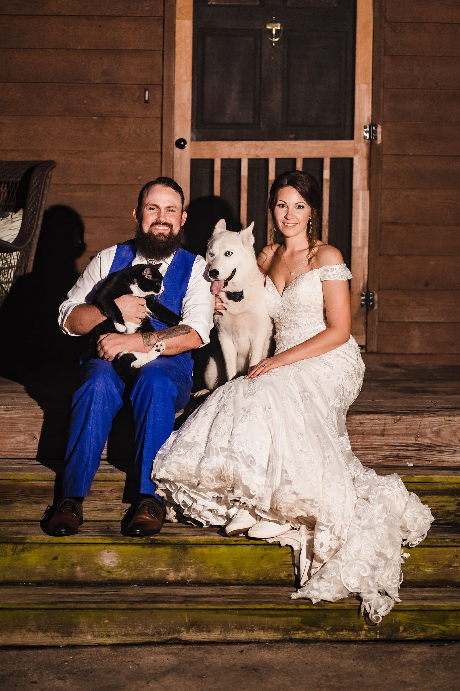 bride and groom pose with their cat and dog