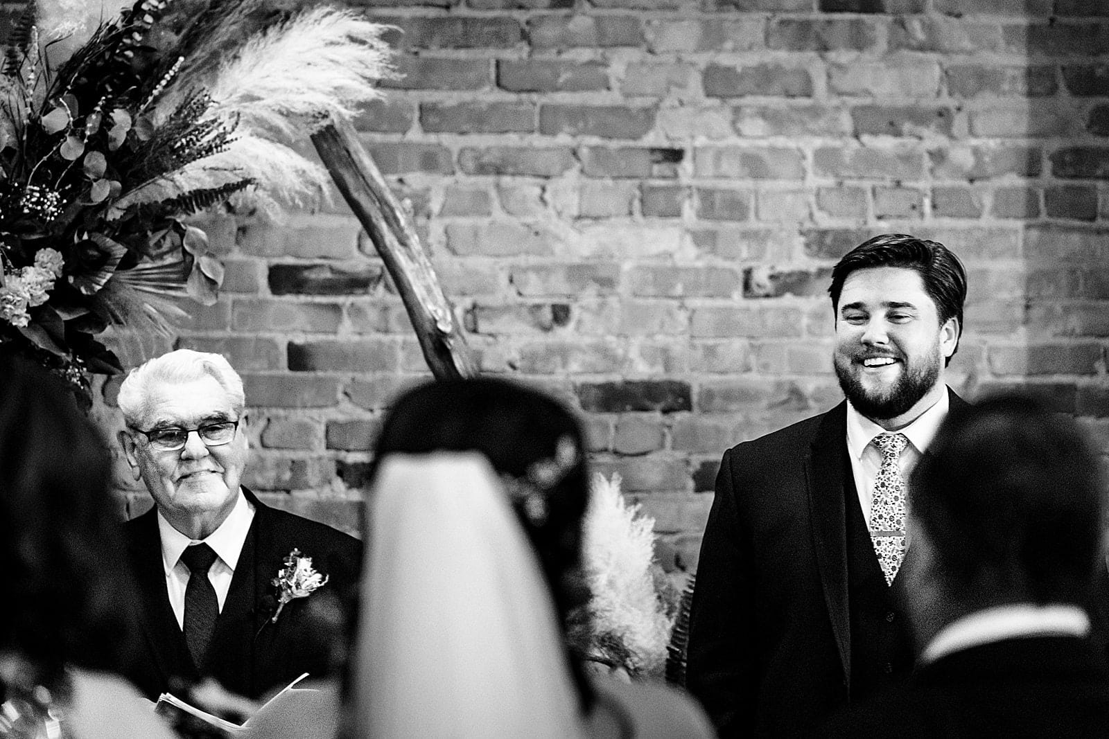 Wedding ceremony at Brick & Mortar events with backdrop made by friends and family of the couple