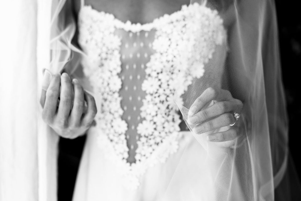 black and white photograph of a woman in a lace and satin mini dress with a veil | photo by Triangle Boudoir