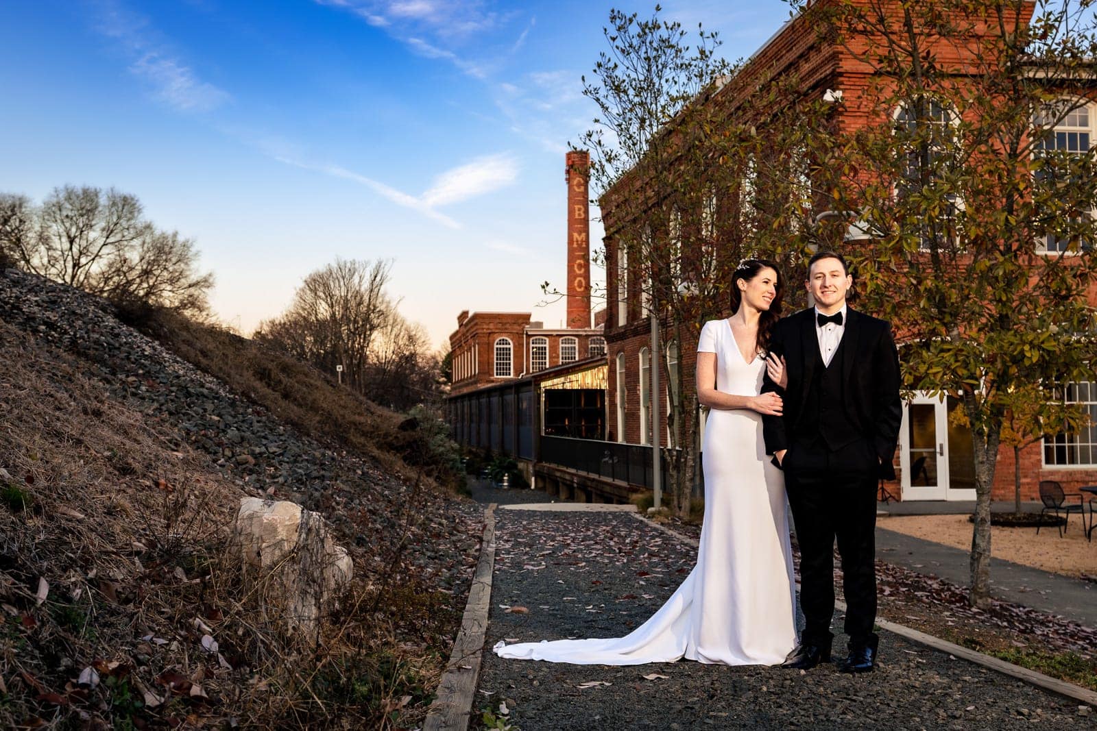 Portrait of a couple in wedding attire outside The Cotton Room wedding venue in Durham, North Carolina | photo by Kivus & Camera