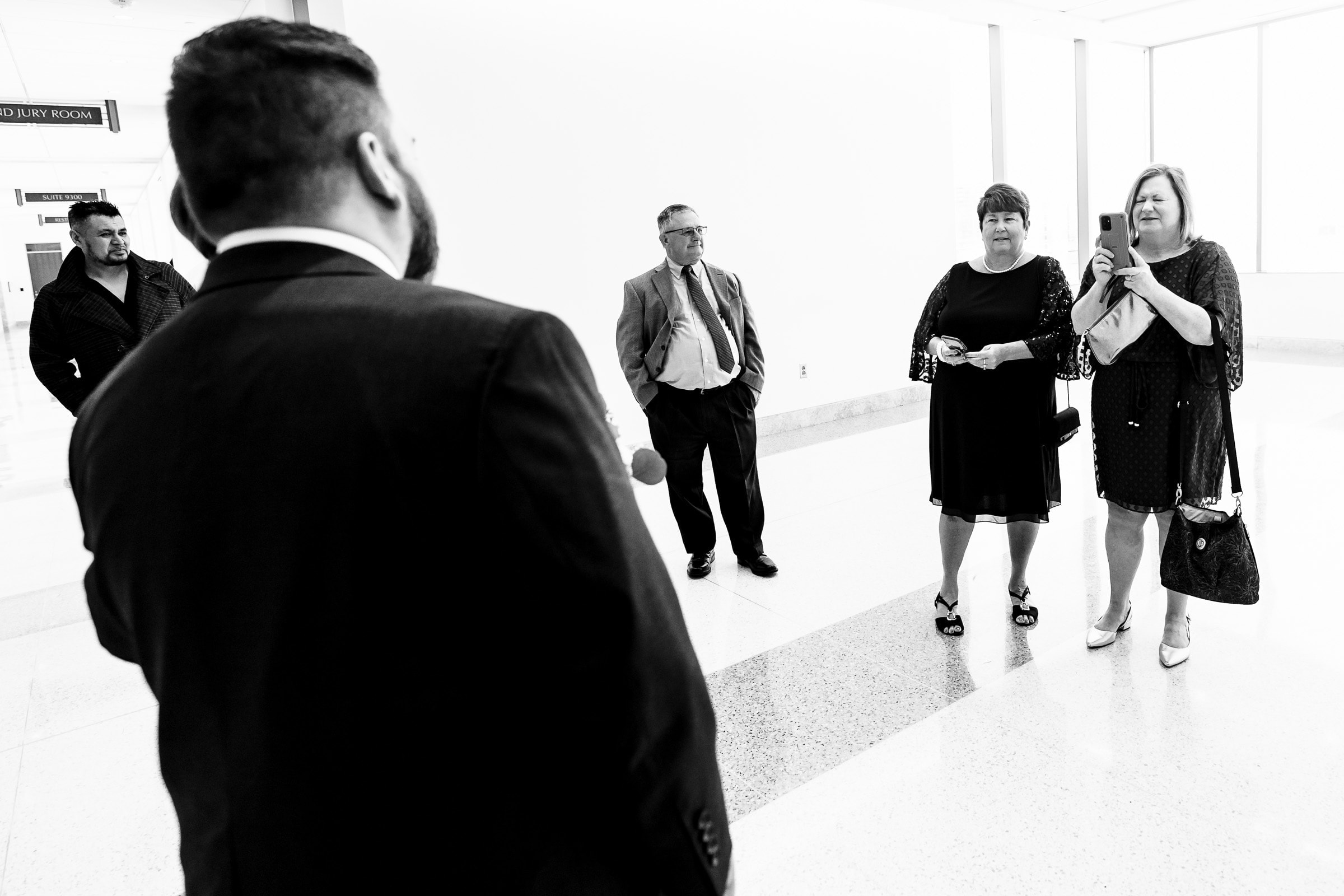 parents look on, taking photos with their cellphones of a couple about to get married | photo by Kivus & Camera