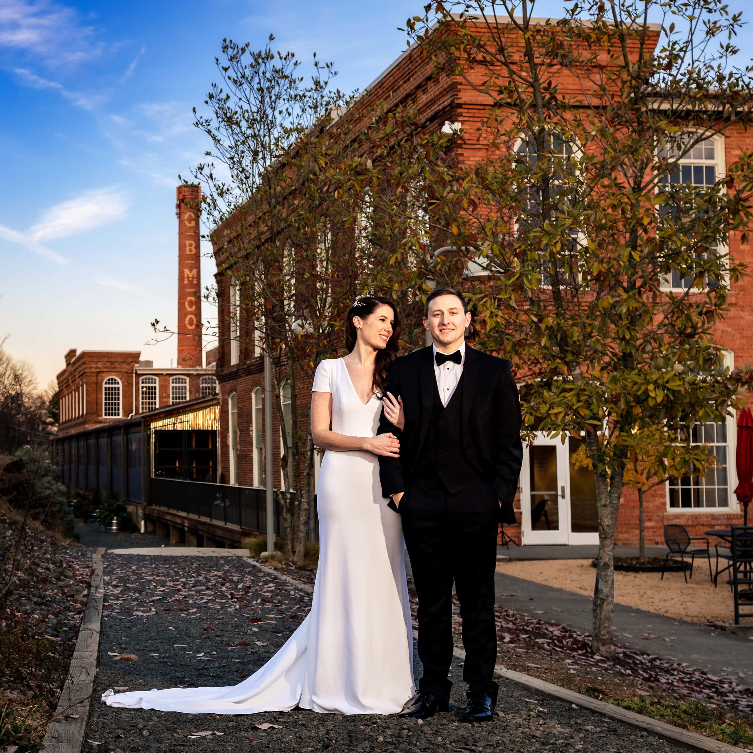 Wedding Portrait with NC wedding venue The Cotton Room in the background | photo by Kivus & Camera