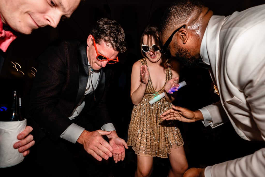 people dancing and clapping at a wedding reception