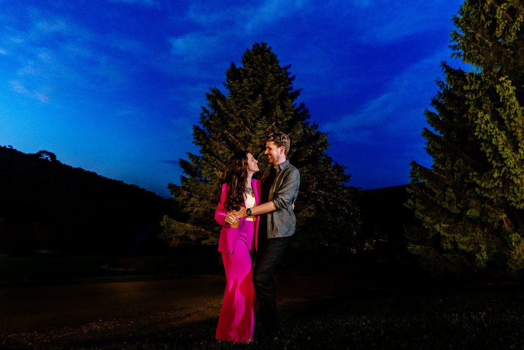 couple poses for a portrait at the welcome party for their mountain lodge wedding.