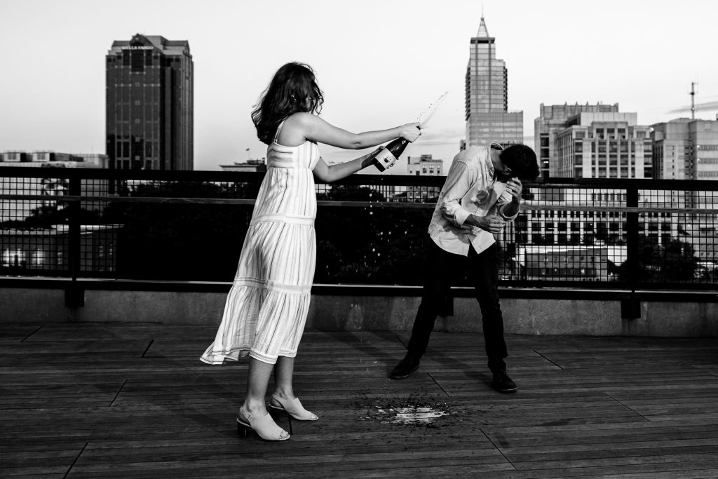 Couple sprays champagne after Raleigh proposal