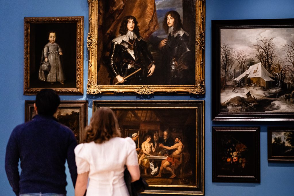 a man in woman holding hands face a gallery wall at the North Carolina Museum of Art | photo by Kivus & Camera