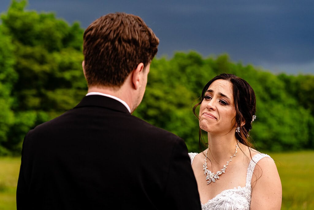 bride holds back tears during mountain wedding ceremony