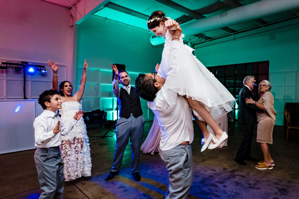 guests cheering on the flower girl at wedding reception