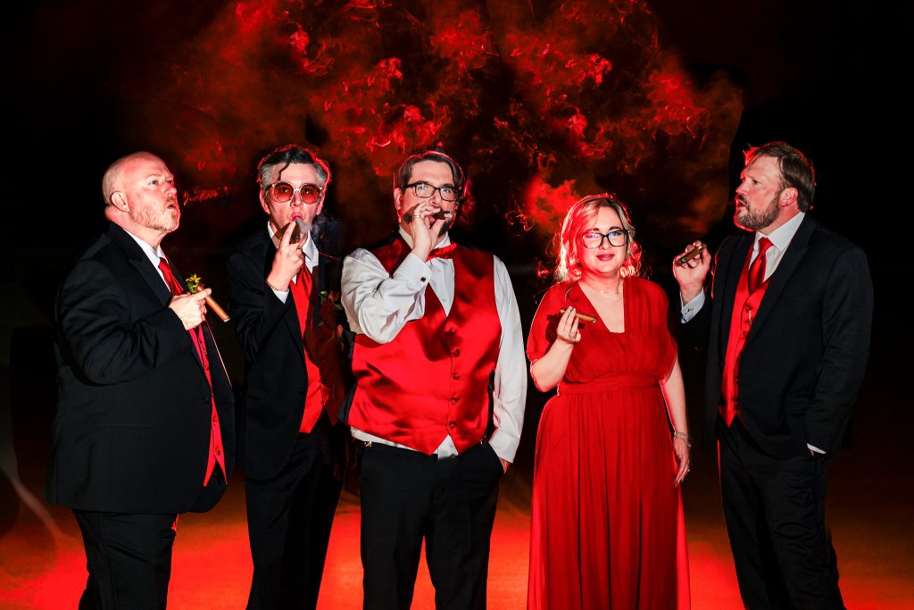 groom in a tuxedo smokes cigars at night with his wedding party| photo by Kivus & Camera