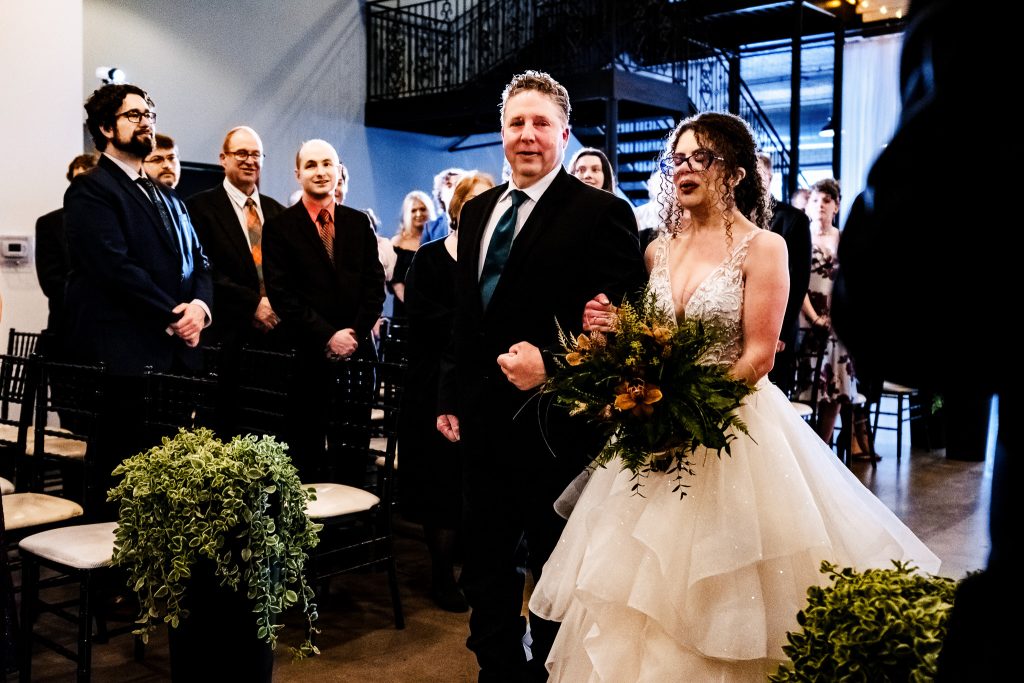 bride and her father walking down the aisle at a wedding ceremony at Market Hall in Raleigh, NC
