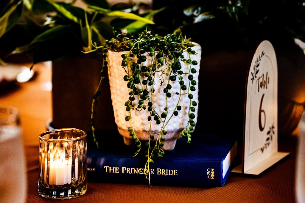wedding reception table decorated with a copy. ofThe Princess Bride and green plants