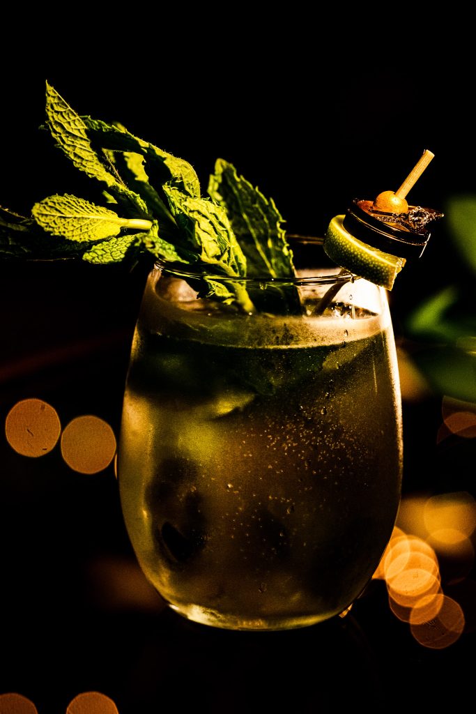 couple's signature wedding cocktail with their wedding rings balanced on the lime garnish