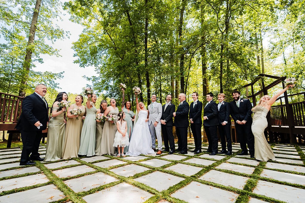 Bride and groom with their wedding party laugh and celebrate