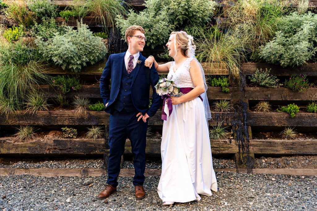 Couple in wedding attire smiles and laughs during their summer wedding in Durham, North Carolina | photo by Kivus & Camera