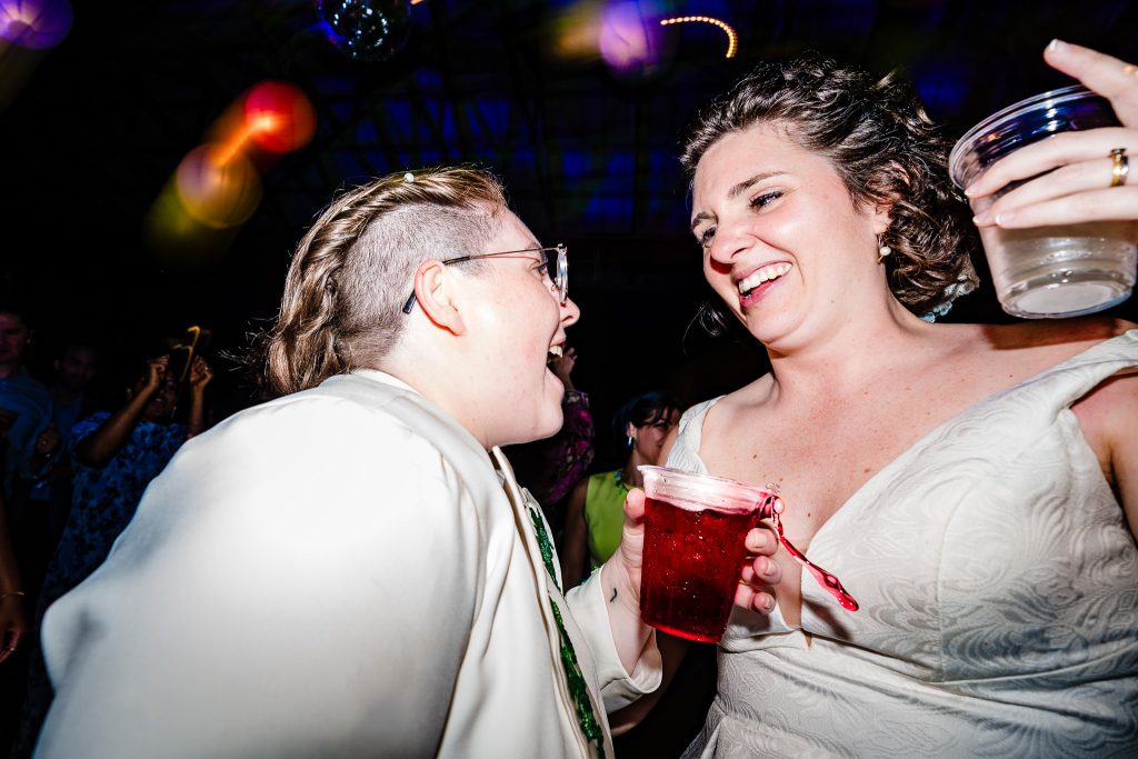 Two women in wedding attire dance together at their wedding | photo by Kivus & Camera
