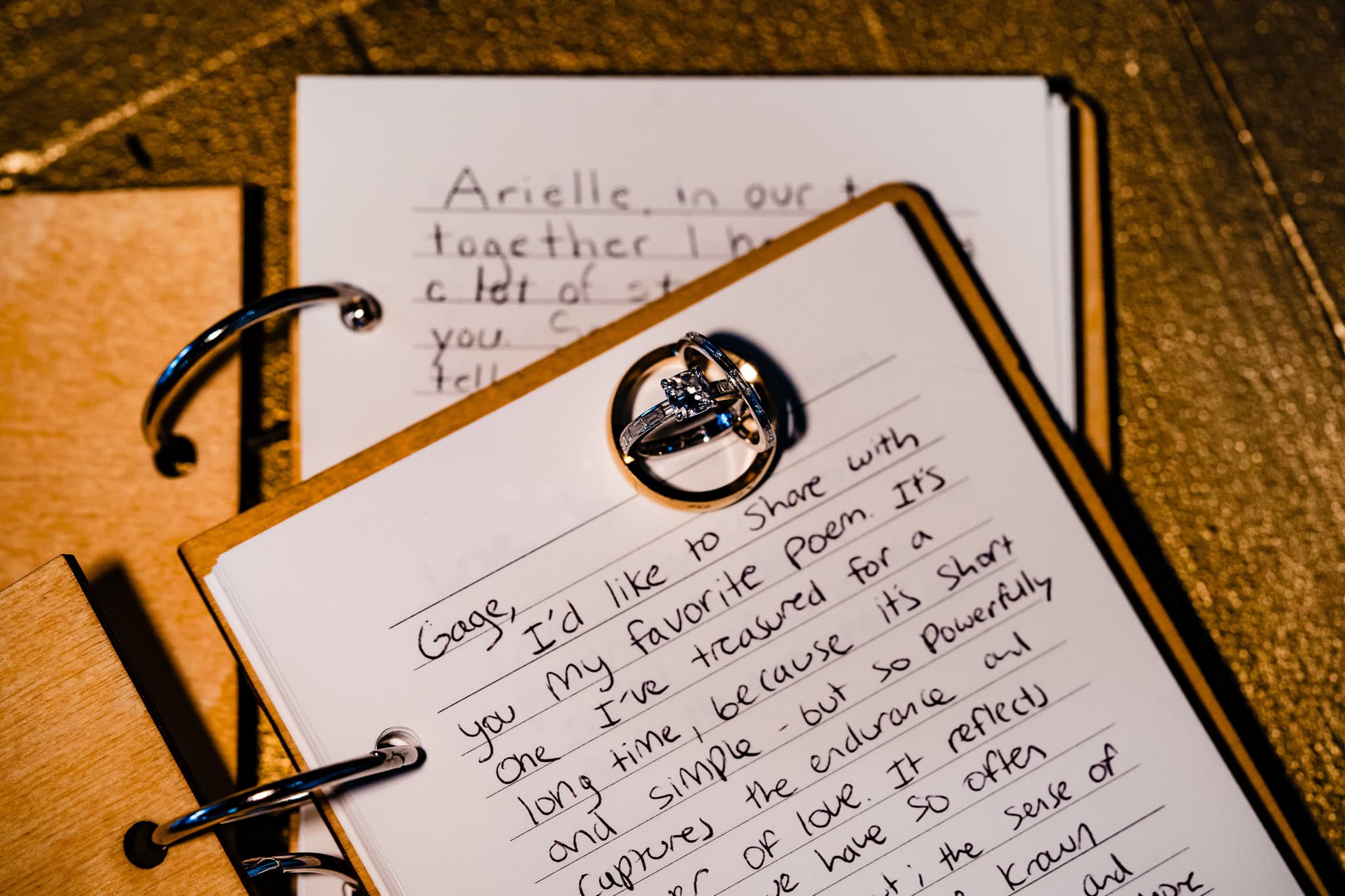 Wedding rings sit atop handwritten wedding vows